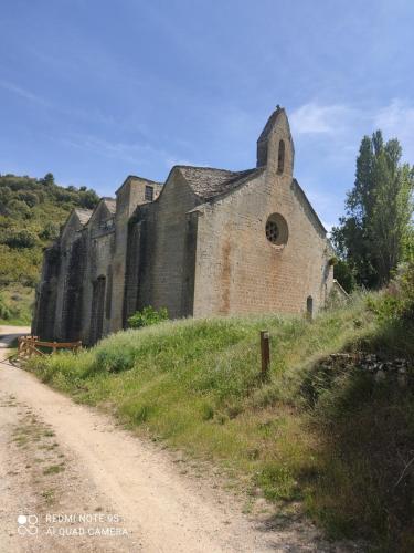 an old church on a hill next to a dirt road at EL PINAR DE BARDENA in Carcastillo