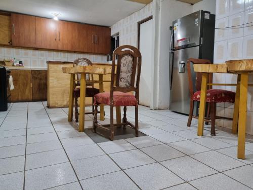 eine Küche mit einem Tisch und Stühlen sowie einem Kühlschrank in der Unterkunft Katchi in San Pedro de Atacama