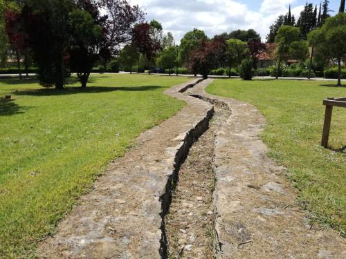 a stone path in a park with a bench at EL PINAR DE BARDENA in Carcastillo
