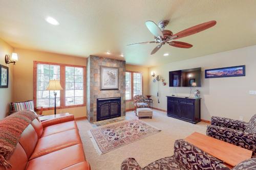 a living room with a ceiling fan and a fireplace at JG Farm Lake Retreat in Joseph