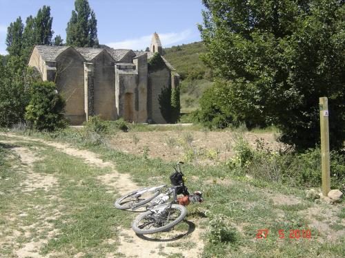 a bike laying on the grass in front of an old building at EL PINAR DE BARDENA in Carcastillo
