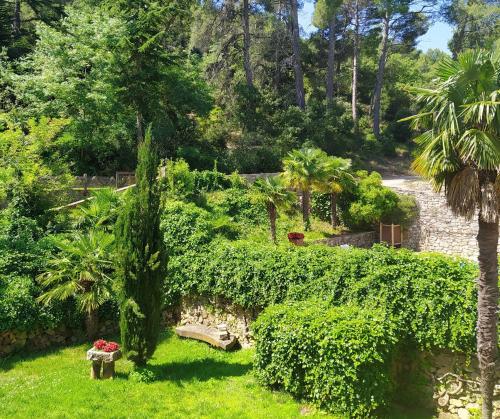 a garden with a bench and trees and bushes at Masia Sagués in Poblet