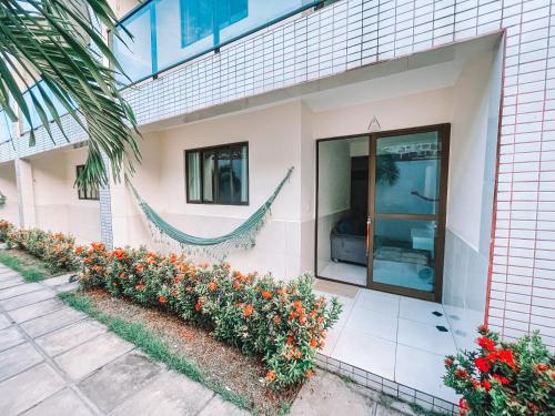 uma casa com flores ao lado dela em Vanilla em Porto de Galinhas