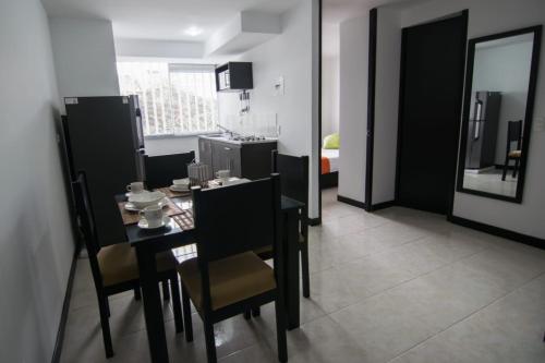 a dining room with a table and chairs and a kitchen at Economico Apto a 3' al Parque del Café in Quimbaya