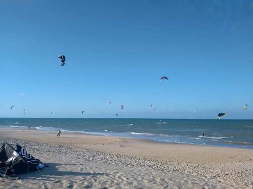a group of people flying kites on the beach at CUMBUCO - Eco Paradise - AP 112 in Caucaia
