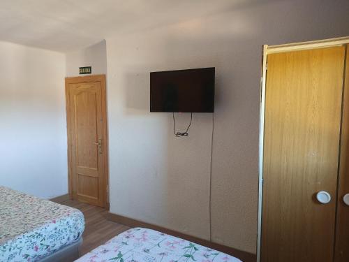 a bedroom with a bed and a flat screen tv on the wall at EL PINAR DE BARDENA in Carcastillo