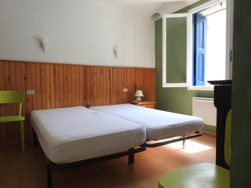 une chambre avec un lit blanc et une fenêtre dans l'établissement Appartement T1 meublé haut vallespir le Tech, à Le Tech