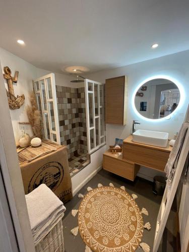 une salle de bain avec une baignoire, un lavabo et un miroir dans l'établissement lou cabanou, à Sainte-Maxime