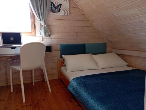 a bedroom with a bed and a desk and a chair at Domki U Wojtka w Niechorzu in Niechorze