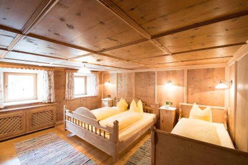 a bedroom with two beds in a room with wooden walls at Steffa Hamat in Ischgl
