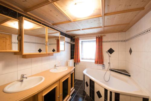 a bathroom with two sinks and a tub at Steffa Hamat in Ischgl