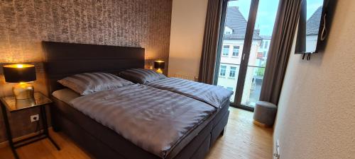 a bed in a bedroom with a large window at Ferienwohnung City Loft Fulda in Fulda