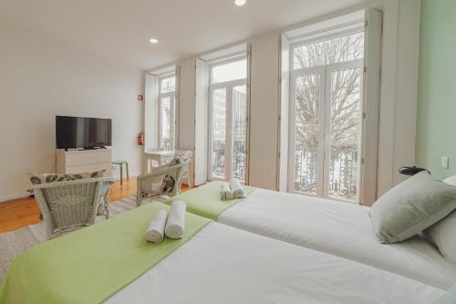 um grande quarto branco com uma cama grande e janelas em Porto Downtown Apartments by Vacationy no Porto