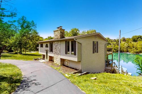 una pequeña casa con una chimenea encima en Camp Rampe Lakefront Cabin, en New Tazewell
