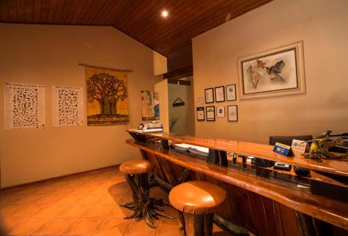a restaurant with a bar with stools in a room at Sunbird Lodge in Phalaborwa