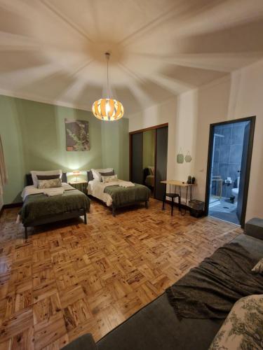 a living room with two beds and a wooden floor at D'aqui e D'acolá - Pardieiros in Pardieiros