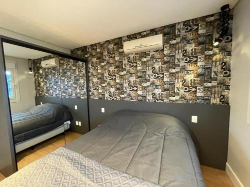 - une chambre avec un lit et un mur recouvert d'autocollants dans l'établissement L' Adresse Reserve 203A, à Gramado
