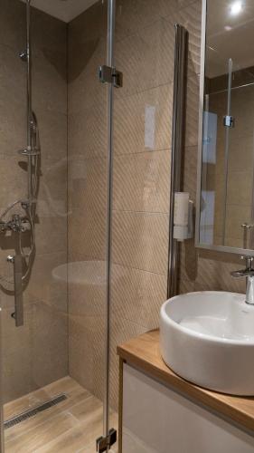 a bathroom with a sink and a glass shower at HA Hotel Mostar in Mostar