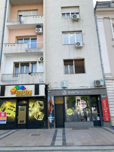 a building on a city street with stores at Bonanza Apartments in Niš