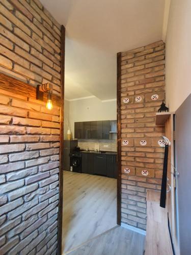 a room with a brick wall and a kitchen at Linden apartment with Air condition in Budapest