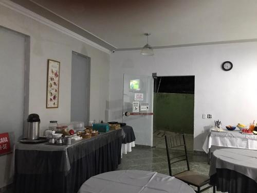 una habitación con 2 mesas y una puerta verde en HOTEL BELA VISTA NOVA ODESSA en Nova Odessa