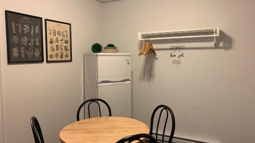 a kitchen with a table and a refrigerator at Motel Des Cascades in Baie-Saint-Paul