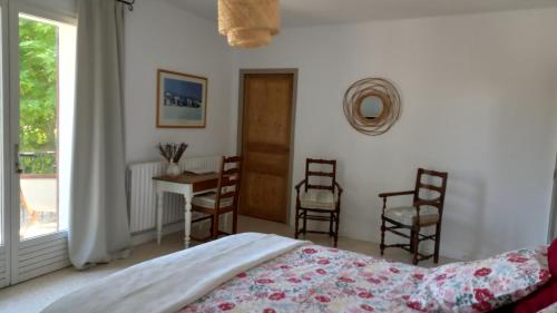 sypialnia z łóżkiem, stołem i krzesłami w obiekcie La Maison Ocre w mieście Rochegude