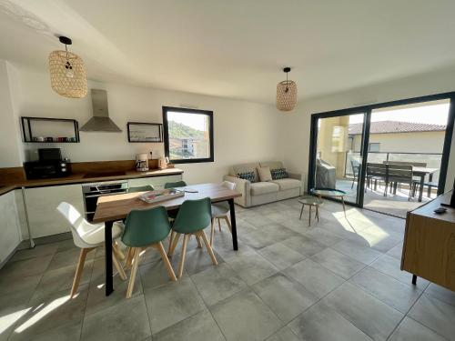 a kitchen and living room with a table and chairs at Superbe T3 NEUF VUE MER in Propriano