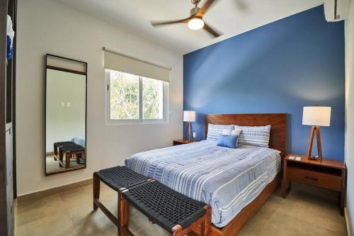 Un dormitorio con una cama grande con una pared azul. en Macbeth - Rooftop with Jacuzzi & Beach Club Access, en Tulum