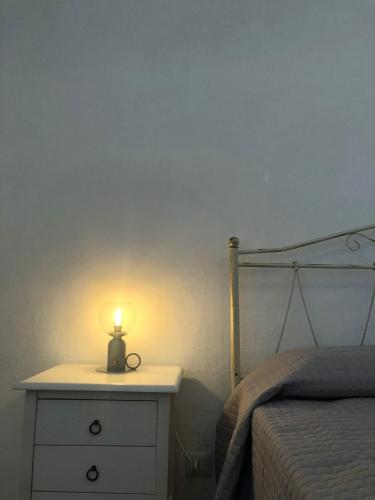 a bedroom with a bed and a lamp on a dresser at Casa Fortuna in Cisternino