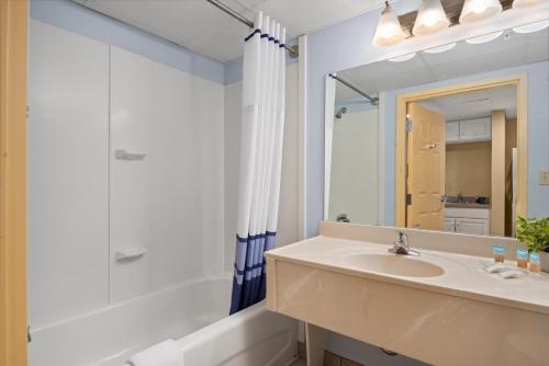 a bathroom with a sink and a shower and a mirror at Bonita Beach Hotel in Ocean City