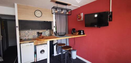 a kitchen with a counter and a red wall at Les pieds dans l'eau sur l'Ile du Frioul in Marseille