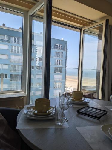 a dining table with a view of the ocean at Studio Sun south- seaview-sea at 15meter-Ostend in Ostend