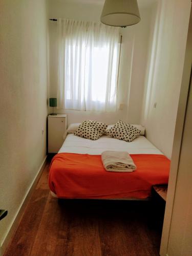 ein Schlafzimmer mit einem Bett mit einer roten Decke und einem Fenster in der Unterkunft Victoria home in Málaga