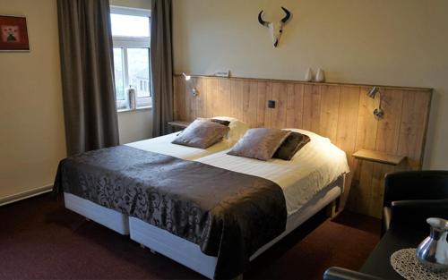 a bedroom with a large bed with a wooden headboard at Fleurie de Montagne in Mechelen