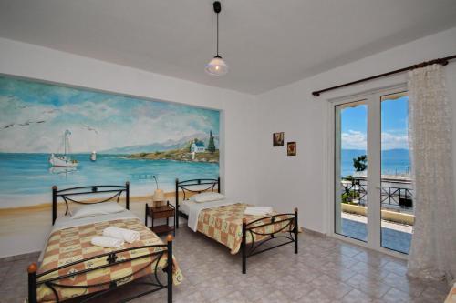 a bedroom with two beds and a painting on the wall at KIPRIANOS - STUDIOS in Loutra Edipsou