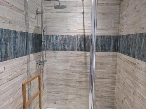 eine Dusche im Bad mit Holzwänden in der Unterkunft Chambre double indépendante BALI au sein du domaine PASSELOUP in Liergues