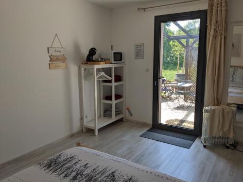 a living room with a door open to a patio at Chambre double indépendante BALI au sein du domaine PASSELOUP in Liergues