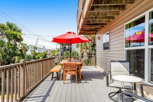 a patio with a table and an umbrella at Compass Rose II in Folly Beach