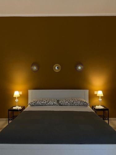 a bedroom with a large bed with two lights on the wall at Nenetta Rooms & Suites Monopoli in Monopoli