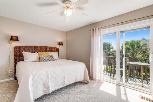 a bedroom with a bed and a large window at Compass Rose II in Folly Beach