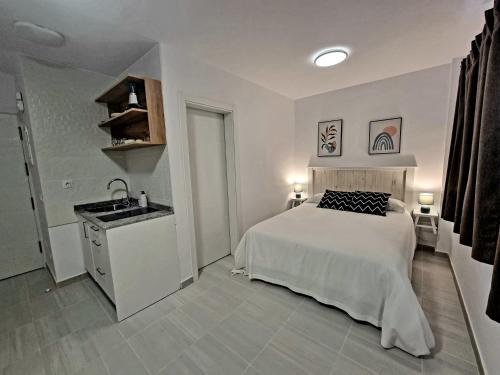 um quarto branco com uma cama e um lavatório em Cardón Jandía 2B em Morro del Jable