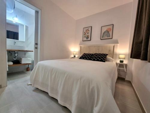 um quarto branco com uma cama grande e uma casa de banho em Cardón Jandía 2B em Morro del Jable