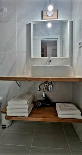 a bathroom with a sink and a shelf with towels at Cardón Jandía 1A in Morro del Jable