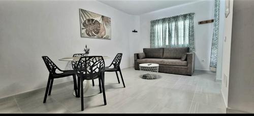 uma sala de estar com uma mesa e cadeiras e um sofá em Cardón Jandía 1B em Morro del Jable