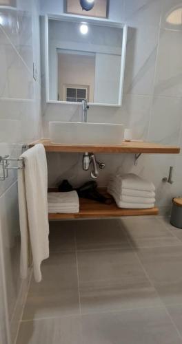 a bathroom with a sink and a mirror and towels at Cardón Jandía 1B in Morro del Jable