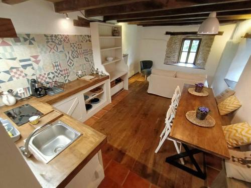 uma cozinha e sala de estar com uma mesa e um lavatório em Granja Labrada: Alojamiento con caballos em Mañón