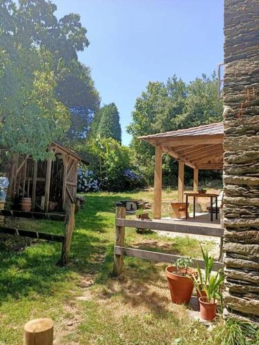 a garden with a wooden fence and a pavilion at Granja Labrada: Alojamiento con caballos in Santa María