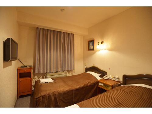 a hotel room with two beds and a television at Famy Inn Makuhari - Vacation STAY 16036v in Chiba