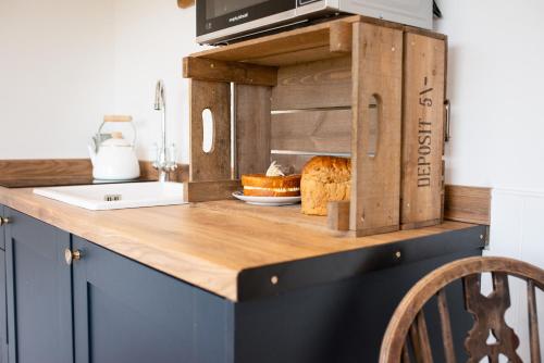 a kitchen counter top with a loaf of bread on it at Drift View Shepherds Hut in Melton Mowbray